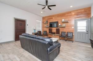 a living room with a leather couch and a television at Welcome to Coastal Serenity – your perfect vacation retreat by the sea in Galveston