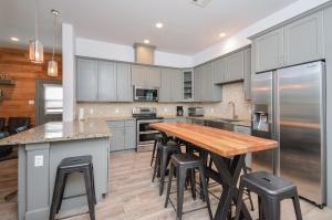 a large kitchen with a wooden table and stools at Welcome to Coastal Serenity – your perfect vacation retreat by the sea in Galveston