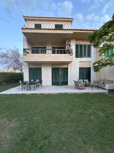 une maison avec des tables et des chaises devant dans l'établissement Villa Hana green beach, à El Alamein