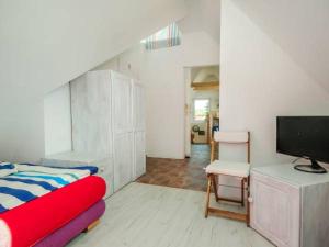 a bedroom with a bed and a desk with a television at Willa Róż Wisełka in Wisełka