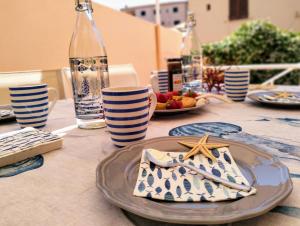 a table with a plate of food and a bottle of water at La Maisonette - Centro storico in La Maddalena