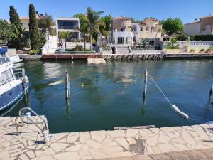 a boat is docked in a river with houses at Puerto Rico 6 in Empuriabrava