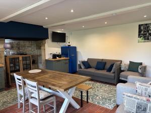 a living room with a table and a couch at Comfortable house for 4 guests in Saint-Côme-du-Mont in Saint-Côme-du-Mont