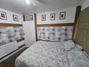 a bedroom with a bed and pictures on the wall at Femros Apartments, 15mins to city center. in Smethwick