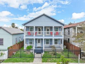 a white house with a fence in front of it at Spacious 2-story house nestled just 3 blocks away from the picturesque seawall in Galveston
