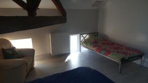 a room with a bed and a couch and a chair at Pause à la campagne au grand air des Pyrénées in Saint-Marcet
