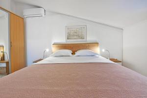a bedroom with a large bed with two pillows at Apartments Pilic in Rošini +78 photos