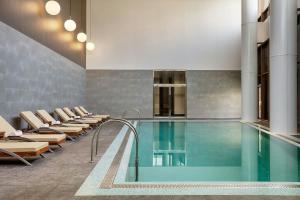 una piscina en un edificio con sillas y una piscina en The Westin Doha Hotel & Spa, en Doha 37 fotos más