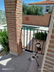 a balcony with a wrought iron fence and two pots at El Balcon a Toledo a 5 minutos del puy du fou in Cobisa