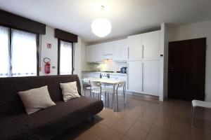 a living room with a couch and a table with chairs at Alby's apartment, nella Motor Valley con parcheggio privato in Formigine
