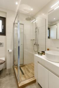 a white bathroom with a shower and a sink at Casa al Mare in Nea Roda +109 photos