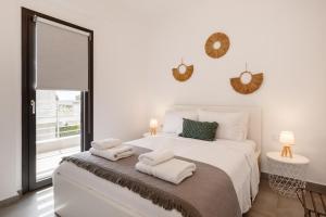 a bedroom with a white bed with towels on it at Casa al Mare in Nea Roda