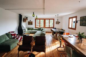 a living room with a green couch and a table at PinoLentejas Mountain Hostel in Alcalá de la Selva