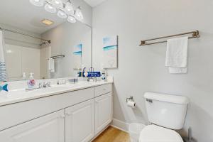 Un baño blanco con lavabo e inodoro. en Holiday Zen, en Carolina Beach 14 fotos más