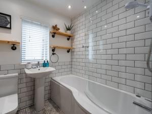 a white bathroom with a tub and a sink at 2 Bed in Anstruther 66733 in Pittenweem +50 photos