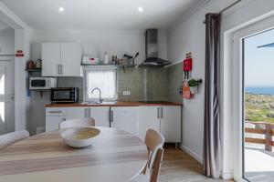 a kitchen and dining room with a table and a window at CASA DA FALÉSIA 28 - Casa in Peniche