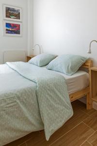 a bedroom with a bed with blue comforter and pillows at CASA DA FALÉSIA 28 - Casa in Peniche