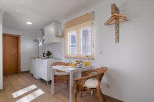 una cucina con tavolo e sedie in una cucina di CASA DA FALÉSIA 28 - Estúdio a Peniche