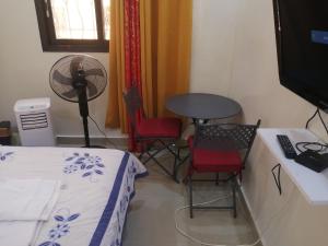 a room with a table and chairs and a fan at Sacre Coeur Hôte DAKAR in Dakar