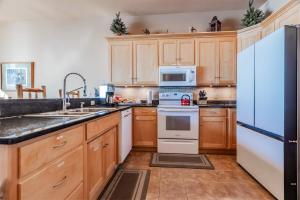 a kitchen with wooden cabinets and a blue refrigerator at Incredible Views w Garage on Lake and bike trail in Tofte