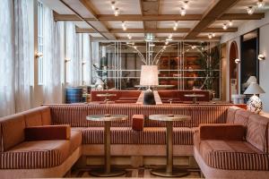 una hall con divani e tavoli in un edificio di De Plesman Hotel The Hague a L'Aia
