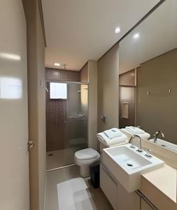 a bathroom with two sinks and a toilet and a shower at Refúgio Manhattan Flat - Silencio, espaço e ao lado do shopping in Campo Grande
