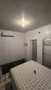 a bedroom with a bed with a cell phone on it at Hostel & Privativo in Manaus