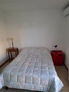 Un dormitorio con una cama y una mesita de noche con una mesa. en Depto moderno en pleno centro, en Rosario 5 fotos más