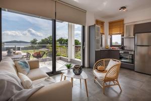a living room with a white couch and a kitchen at Casa al Mare in Nea Roda
