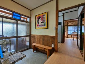 a room with a bench on the wall and a kitchen at Tsugaru House1 in Aomori