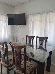 een eettafel met 4 stoelen en een televisie bij Hospedaje Mango y Mar in Coveñas