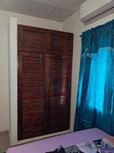 een houten deur in een slaapkamer met een bed bij Hospedaje Mango y Mar in Coveñas