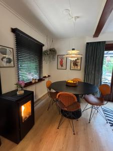 a living room with a table and chairs and a fireplace at Heeren van Norg - het Boshuisje met Jacuzzi & Panorama Sauna in Norg