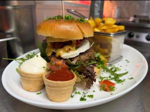 ein Sandwich auf einem Teller mit Eis und Pommes in der Unterkunft Moes Diner Hotel in Schloß Holte-Stukenbrock