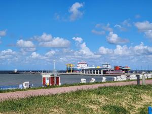 a body of water with a pier in the background at Zimmer Leuchtturm in Dagebüll
