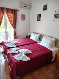 a bedroom with a large red bed with white sheets at Grandma's Pine Apartments in Skála