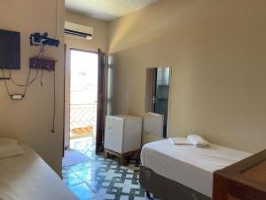 a bedroom with two beds and a door to a patio at Junior Hotel in Anapu