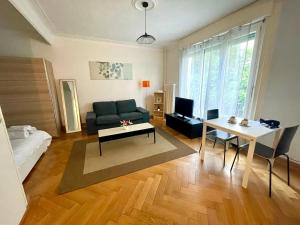 una sala de estar con un sofá y una mesa en Appartement meublé proche de la Gare de Lausanne 12, en Lausana