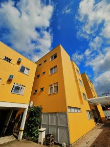 ein gelbes Gebäude vor dem Himmel in der Unterkunft Hotel Pontal in Palhoça