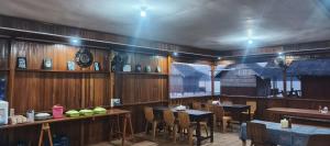 a restaurant with wooden walls and tables and chairs at Happy Homestay Arborek in Besir