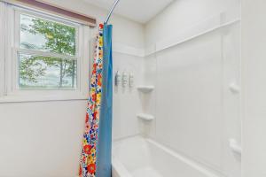 a bathroom with a shower with a blue shower curtain at Duncan Cottage in Ossipee +41 photos