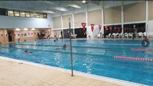 a large swimming pool with people in the water at Kalimera Garden in Ma‘yan Barukh