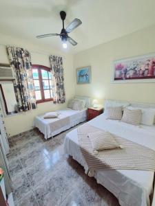 a bedroom with two beds and a ceiling fan at Casa em Condomínio com Piscina Privativa in Araruama