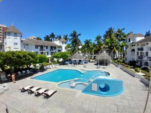 a large swimming pool with chairs and a resort at Beach Studio 24 at Sandcastles in Ocho Rios