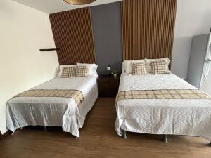 a bedroom with two beds with white comforters at OAK 3B Loft Ejecutivo con Balcón in Estación Pamplona