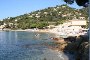 a beach with a group of people in the water at Havre de paix avec vue mer in Le Lavandou