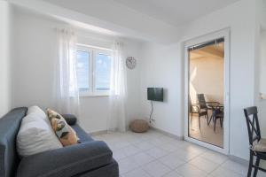 a living room with a couch and a dining room at Apartments Ip in Mandre
