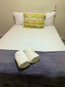 a bed with two white towels on top of it at Apartamento 3 quartos, conforto e espaço no centro in Foz do Iguaçu