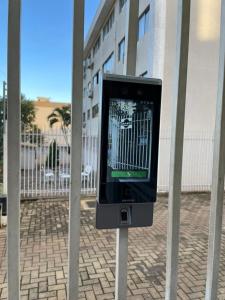 a tv on a pole in front of a fence at Apartamento 3 quartos, conforto e espaço no centro in Foz do Iguaçu