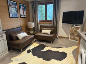 a living room with couches and a flat screen tv at Chalet Figue in Morzine
